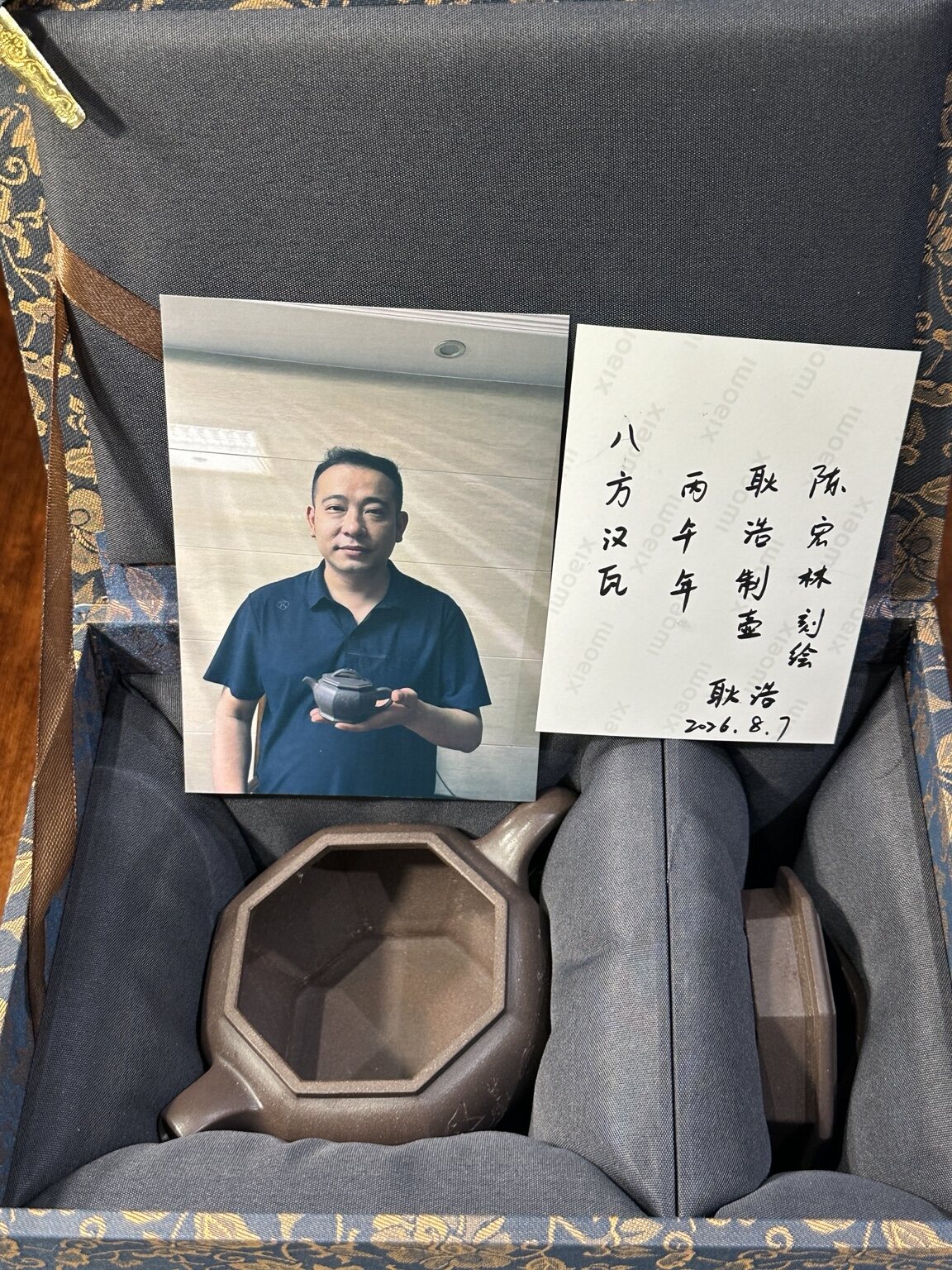 Photograph of Geng Hao holding this teapot with handwritten backing